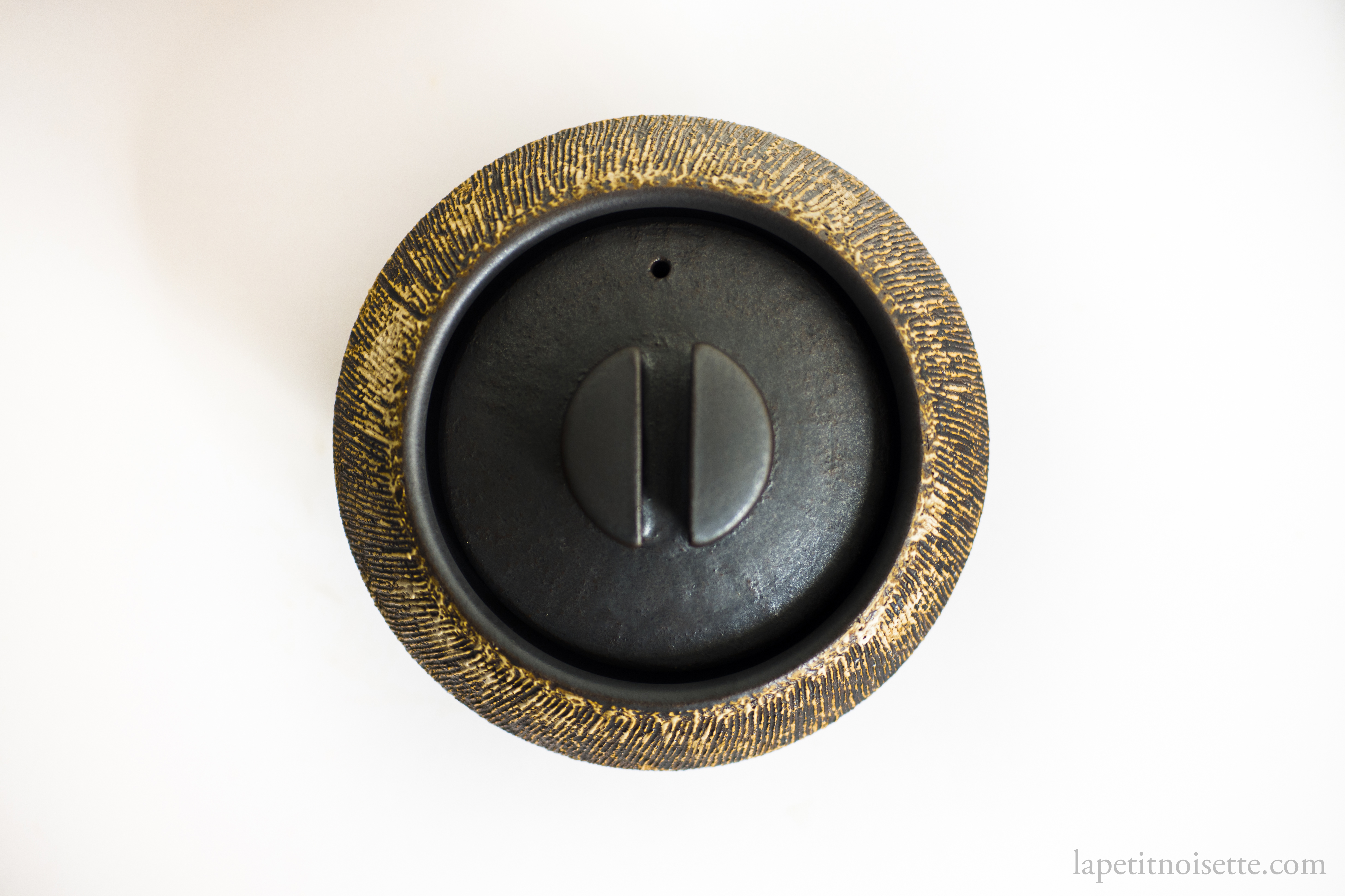 a close up of the design of Anraku Kiln's clay pot rice cooker.