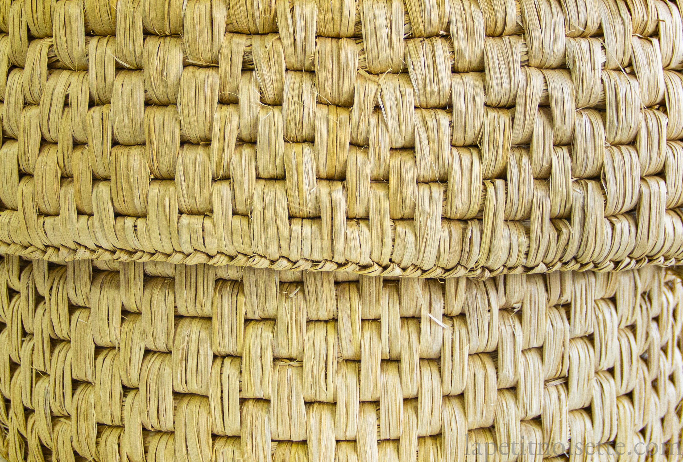 A close up of traditional japanese straw basket know as a warabitsu used to keep rice warm.