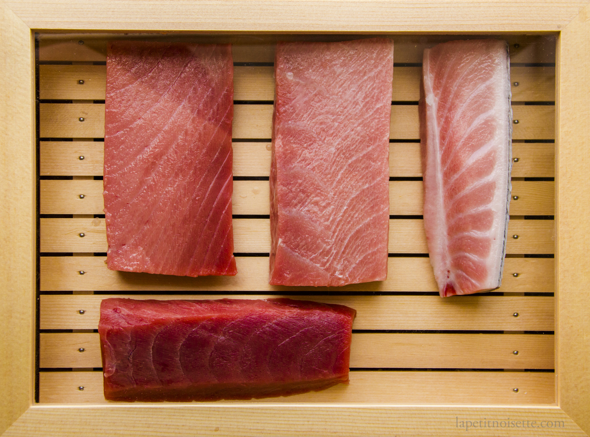 Aged tuna on display in a sushi box.