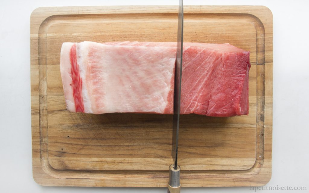 A block of tuna being cut into individual saku.