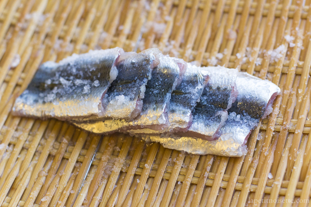 Sardine fillets salted and draining on a Japanese colander in preparation for making nigiri sushi.