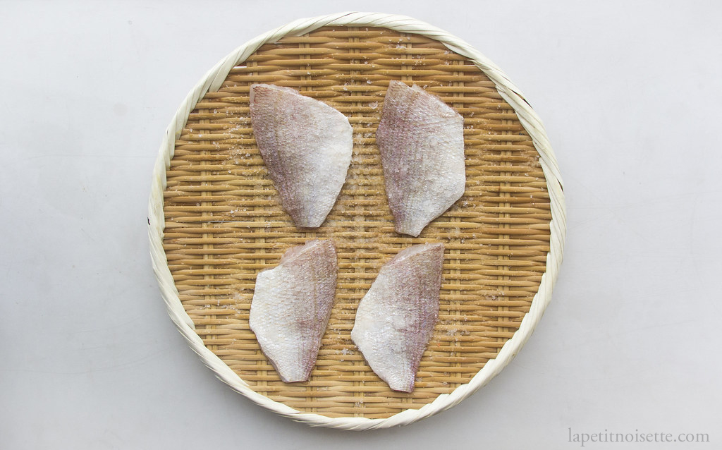 Kasugo fillets being salted on a bamboo colander for edomae sushi.