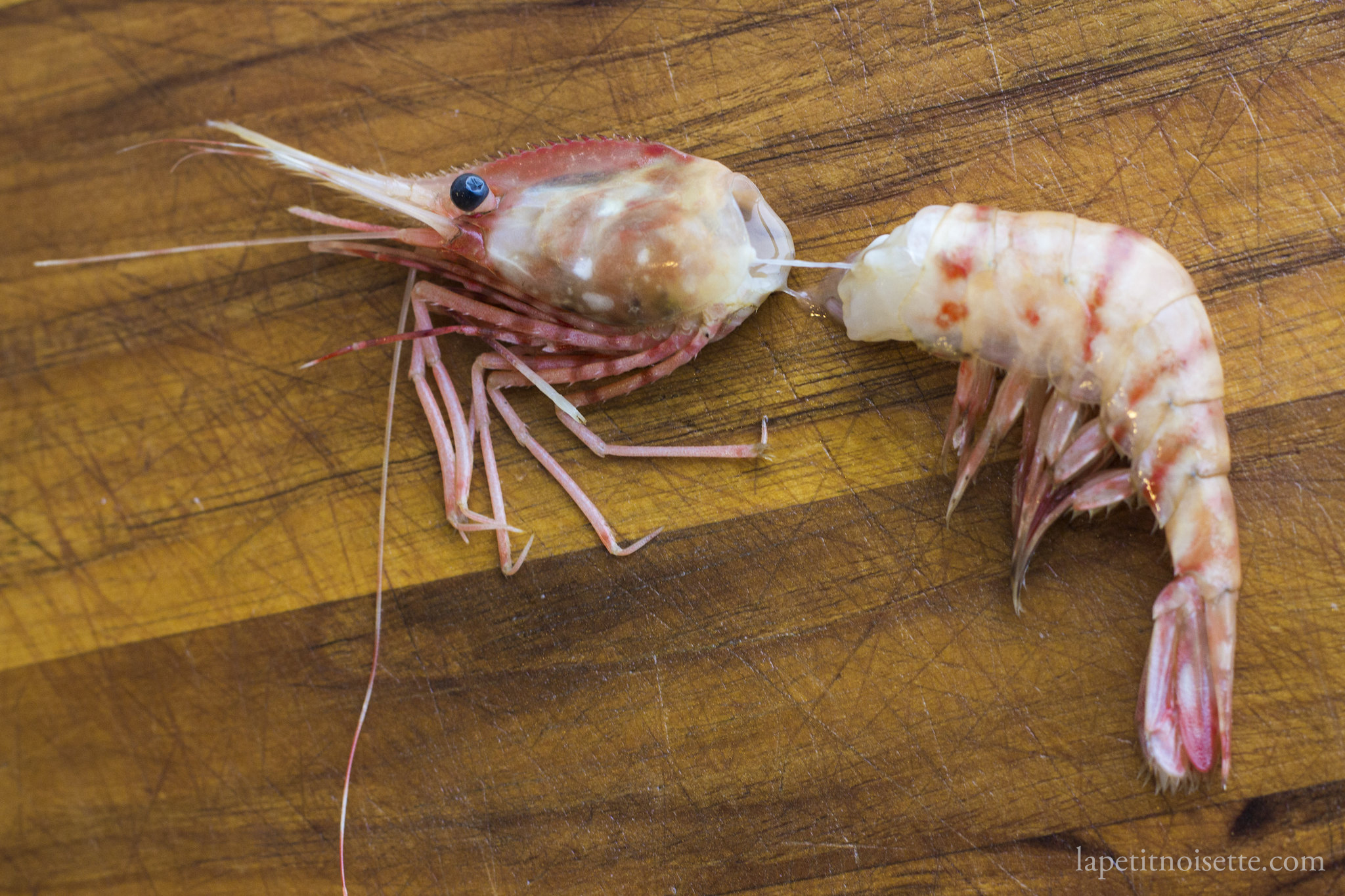 Removing the head of a botan shrimp for sushi.