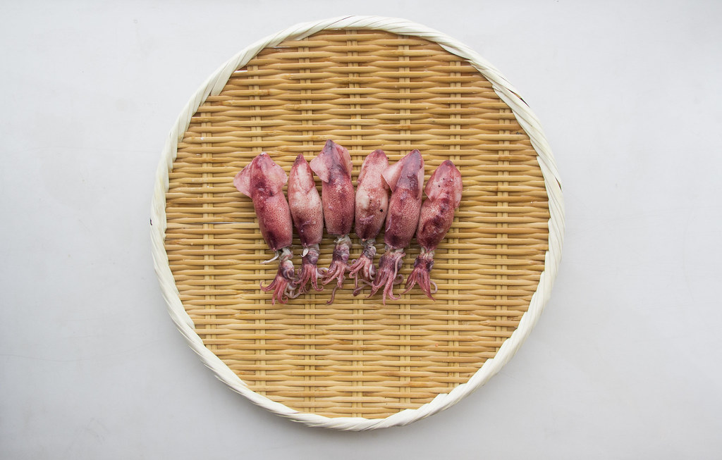 Hotaru Ika being drained on a Japanese bamboo colander for sushi.