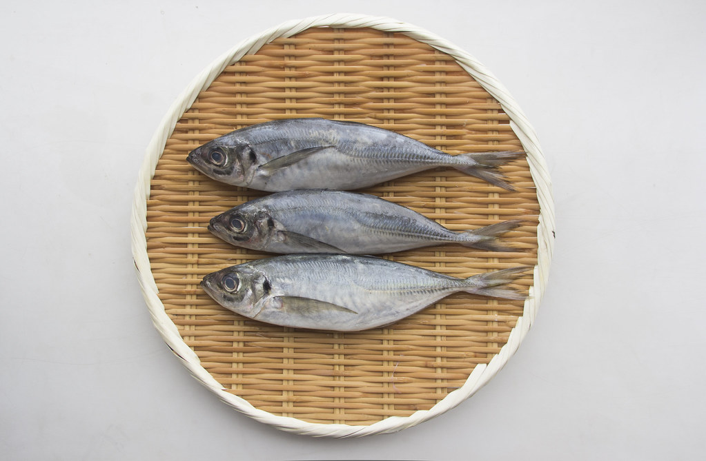 Japanese Aji draining on a bamboo colander of edomae sushi.