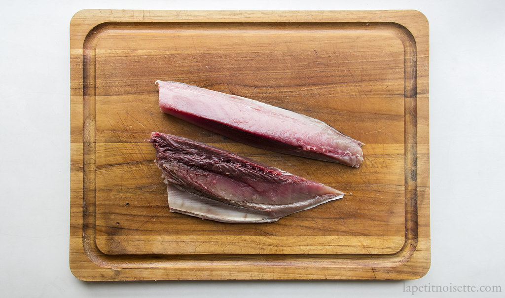 Portioning a skipjack tuna into belly and back fillet for sushi.