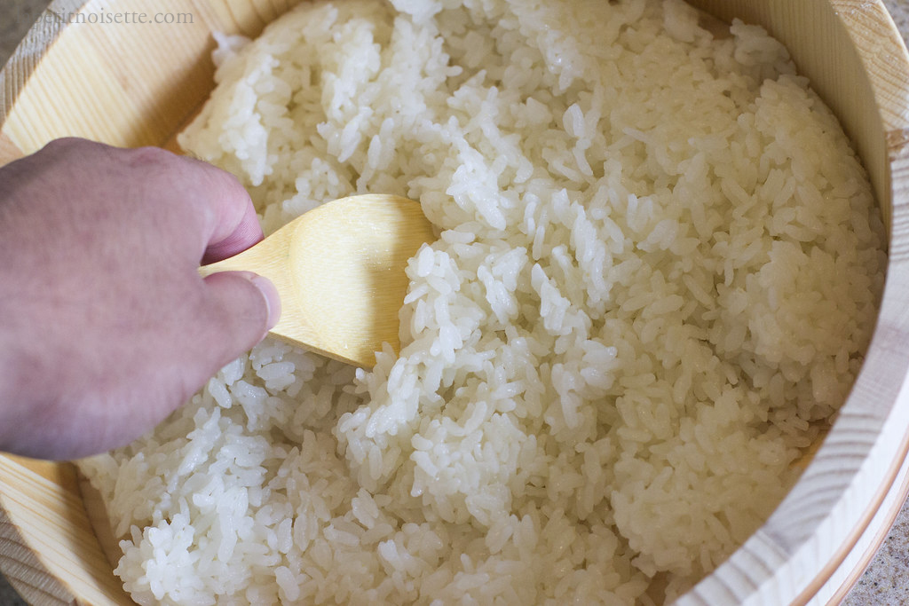 Mixing sushi rice with vinegar.