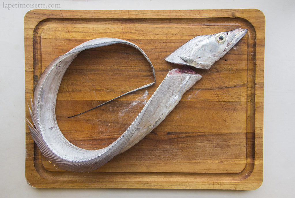 Removing the head of a tachiuo fish for sushi.