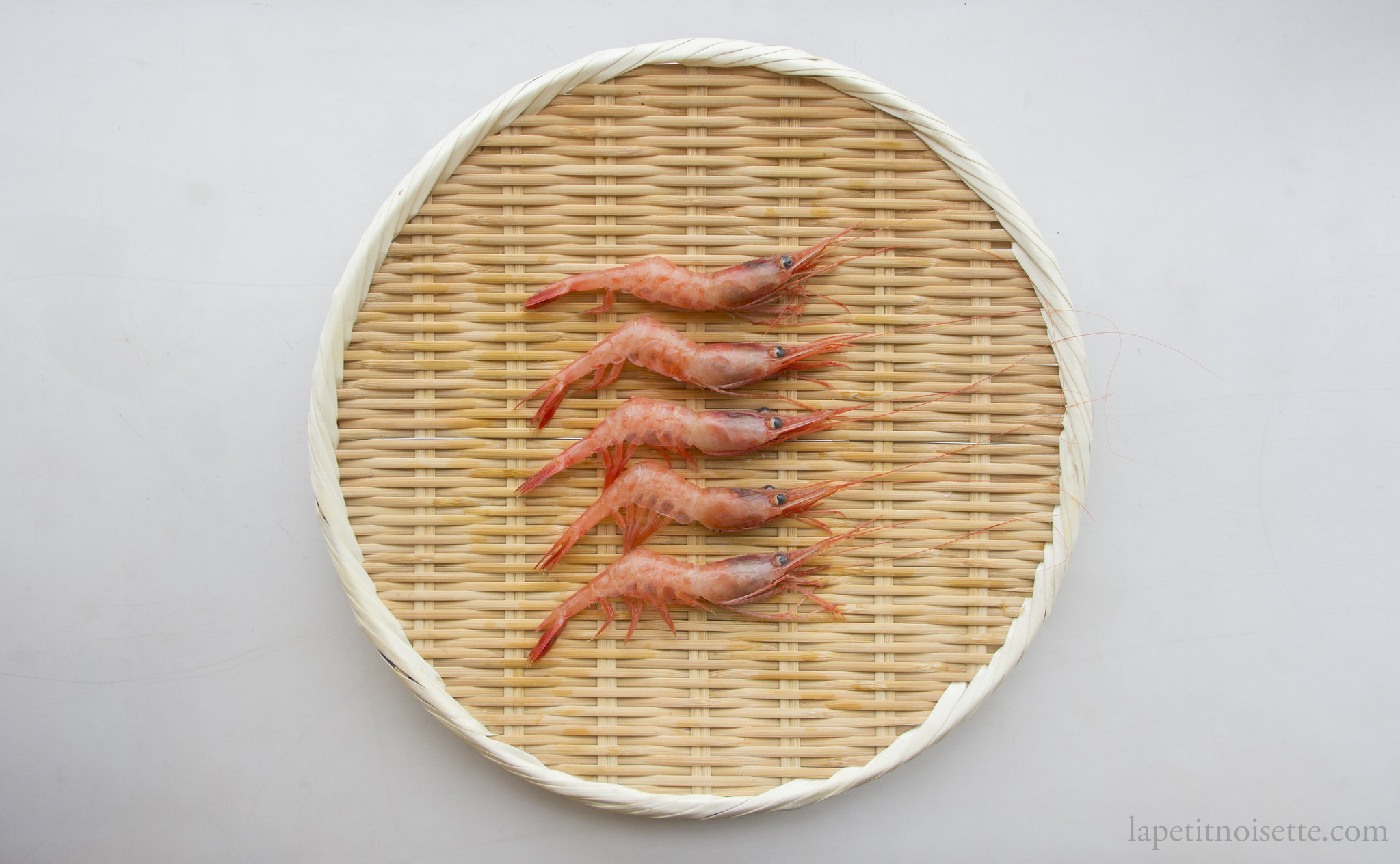 Fresh Japanese sweet shrimp on a bamboo colander for sushi.
