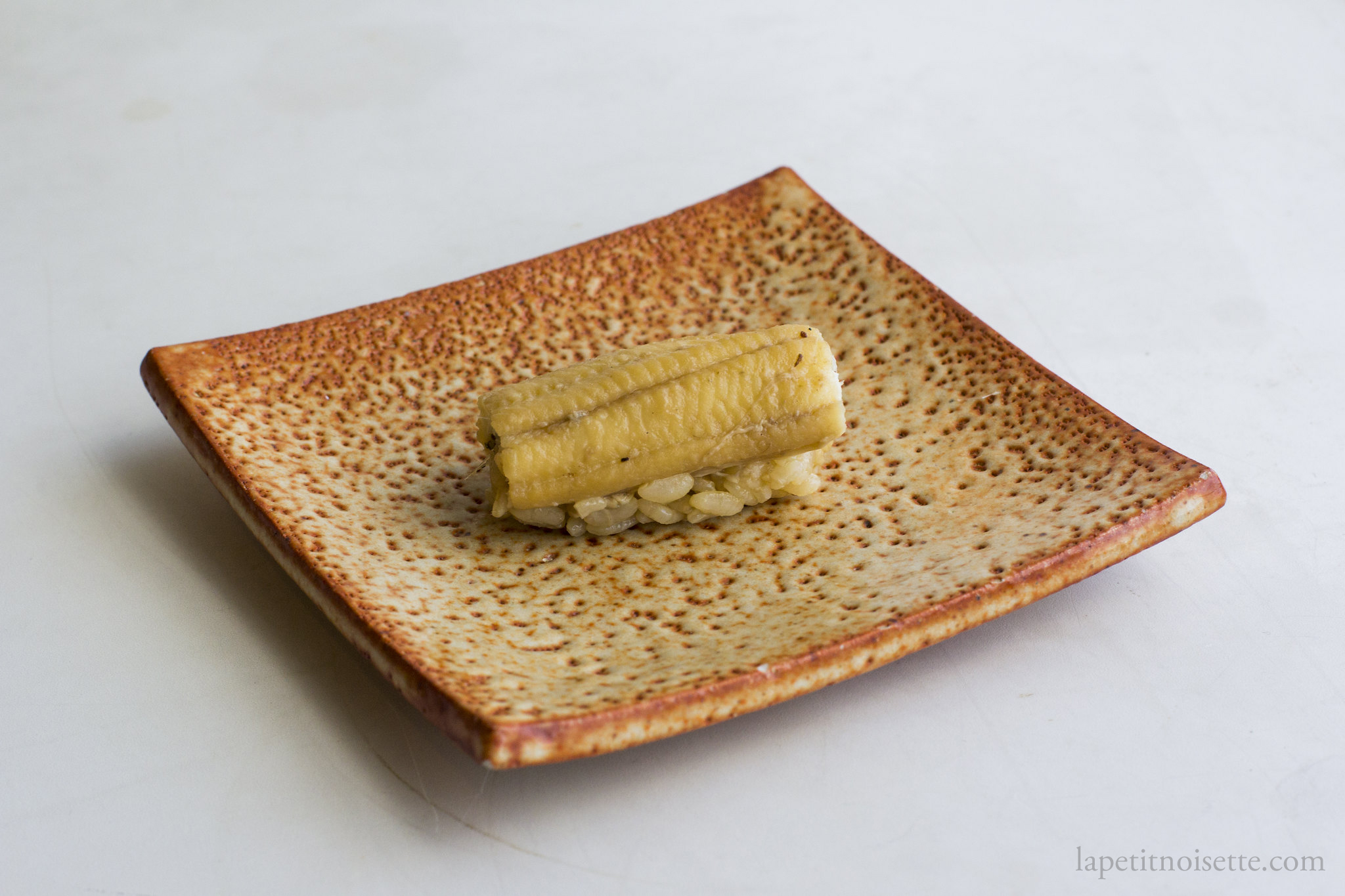 Anago Nigiri Sushi served on a ceramic tile.