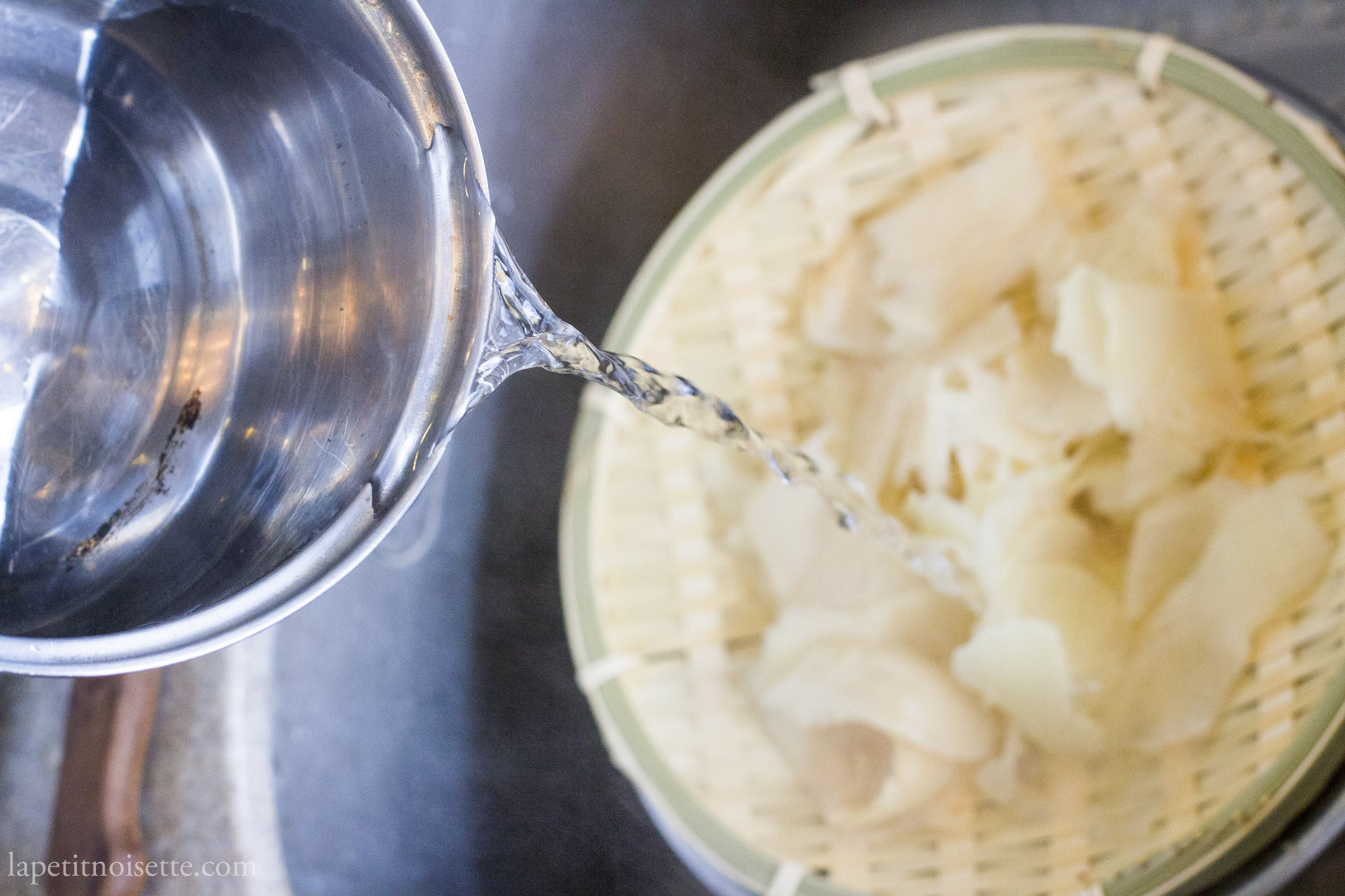 Blanching sliced ginger in hot water.