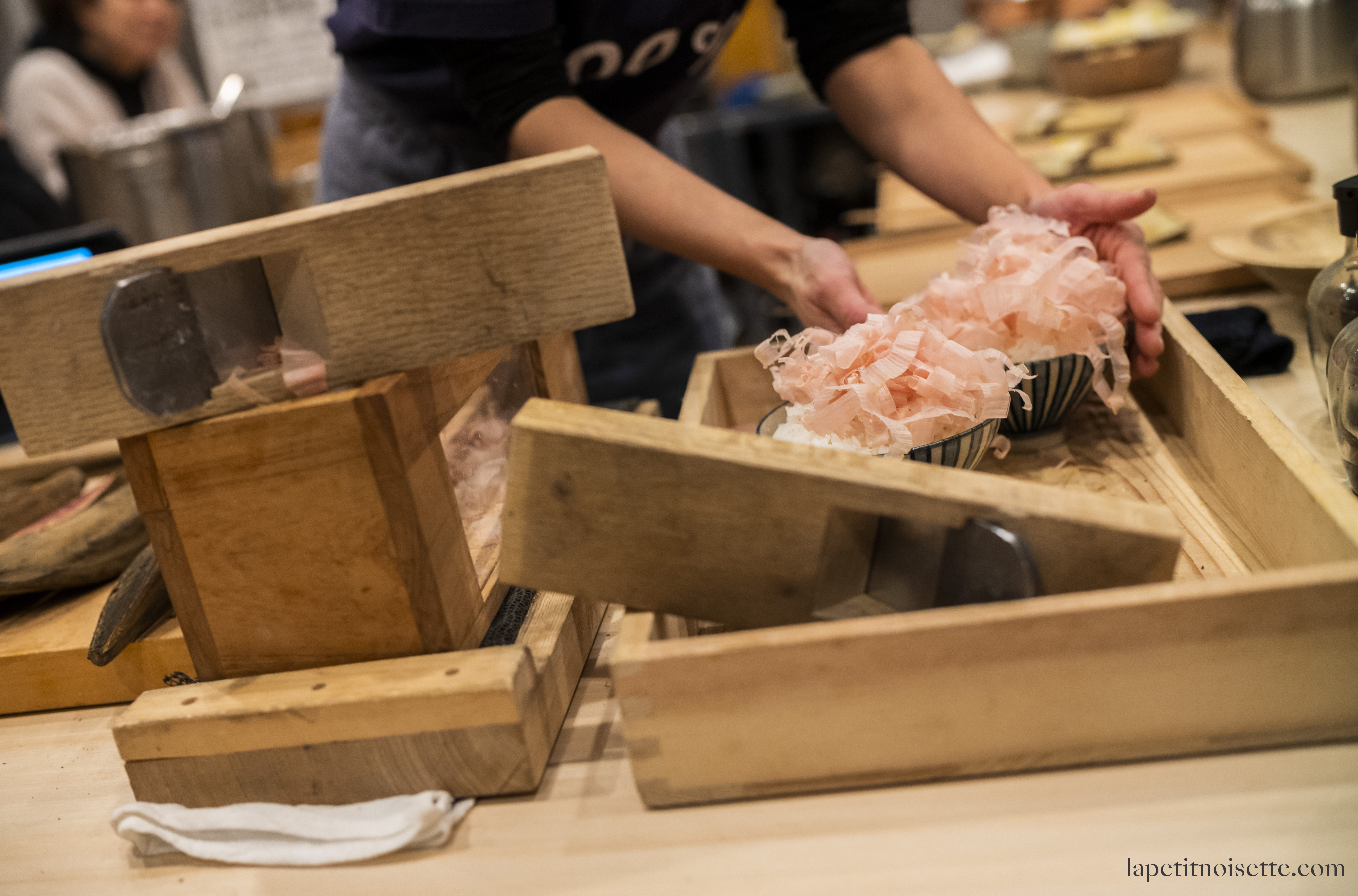 Fresh katsuobushi (鰹節) being shaved on rice for customers at a restaurant in Japan.