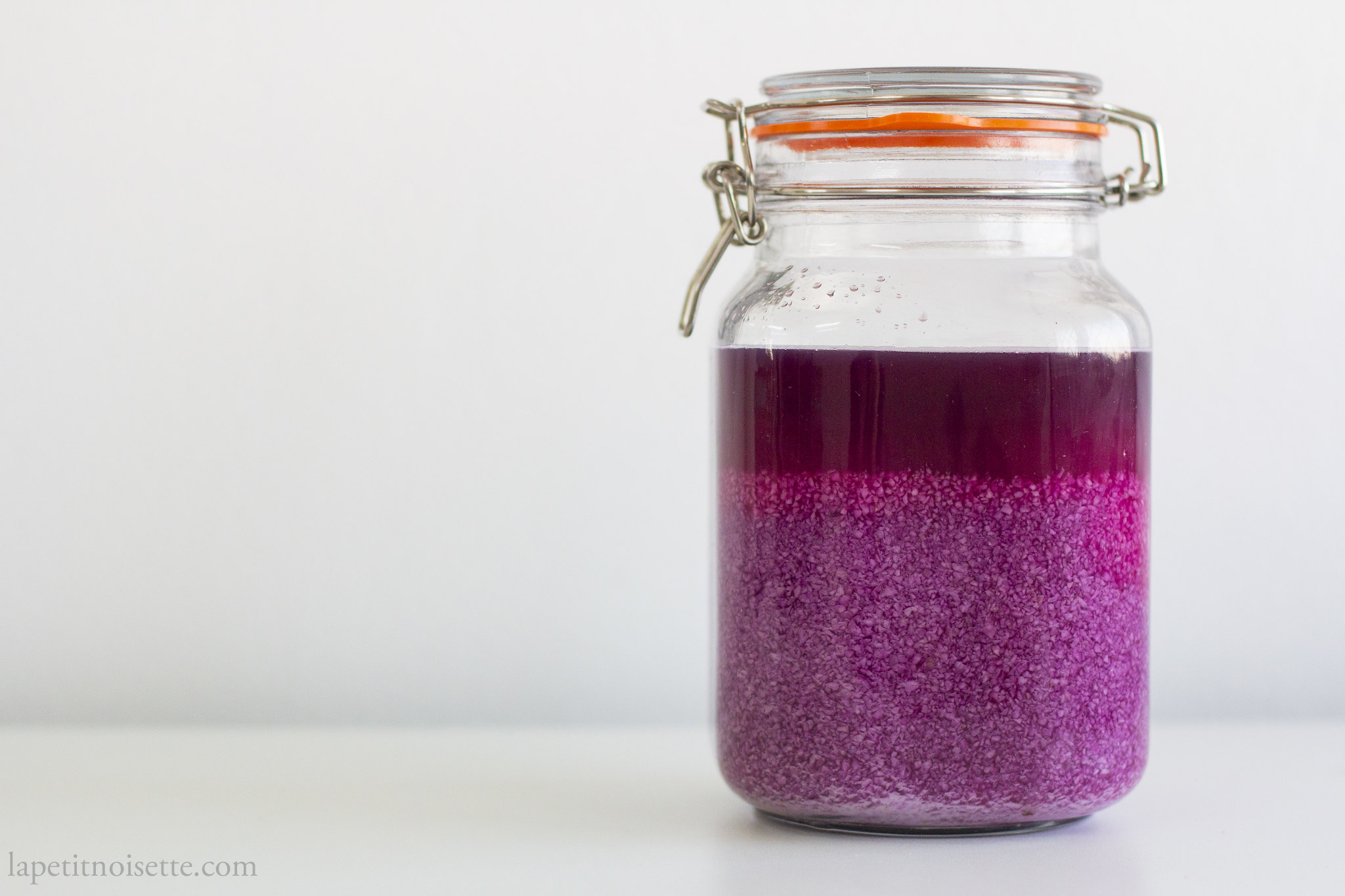 Purple sweet potato vinegar fermenting in a jar.