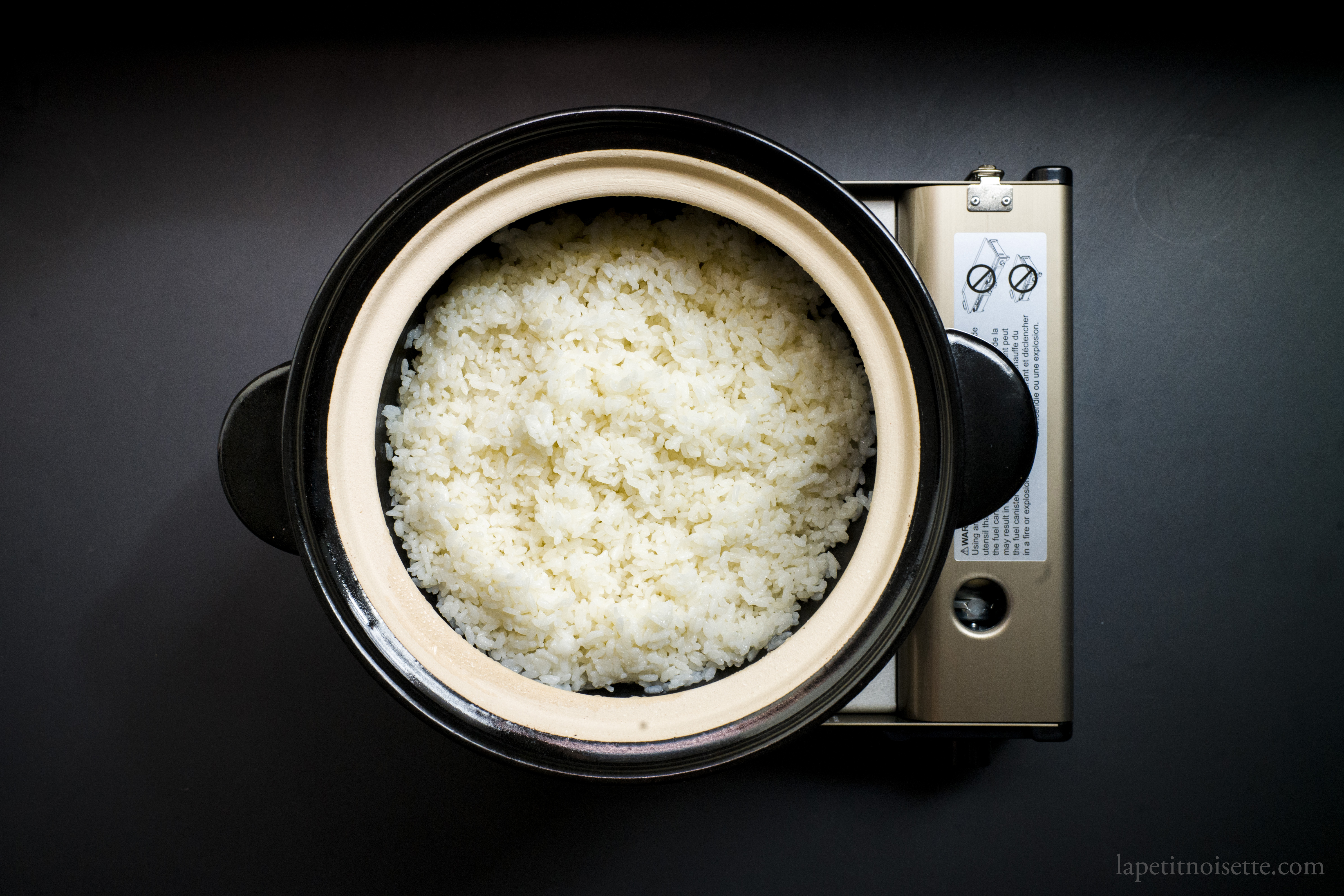 Freshly cooked rice in a traditional double lid clay pot rice cooker.