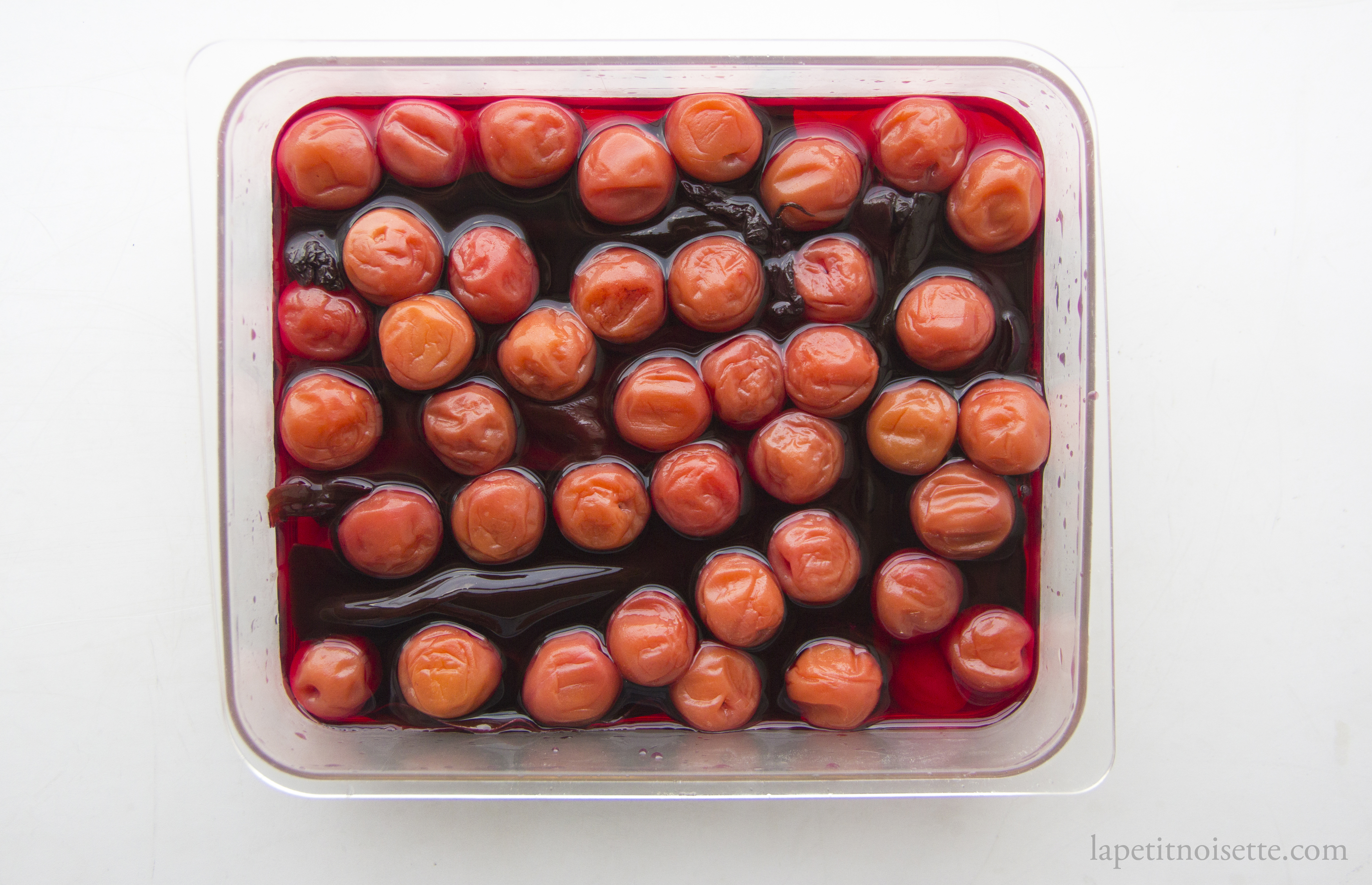 Umeboshi fermenting in a mixture of red shiso leaves and kombu.