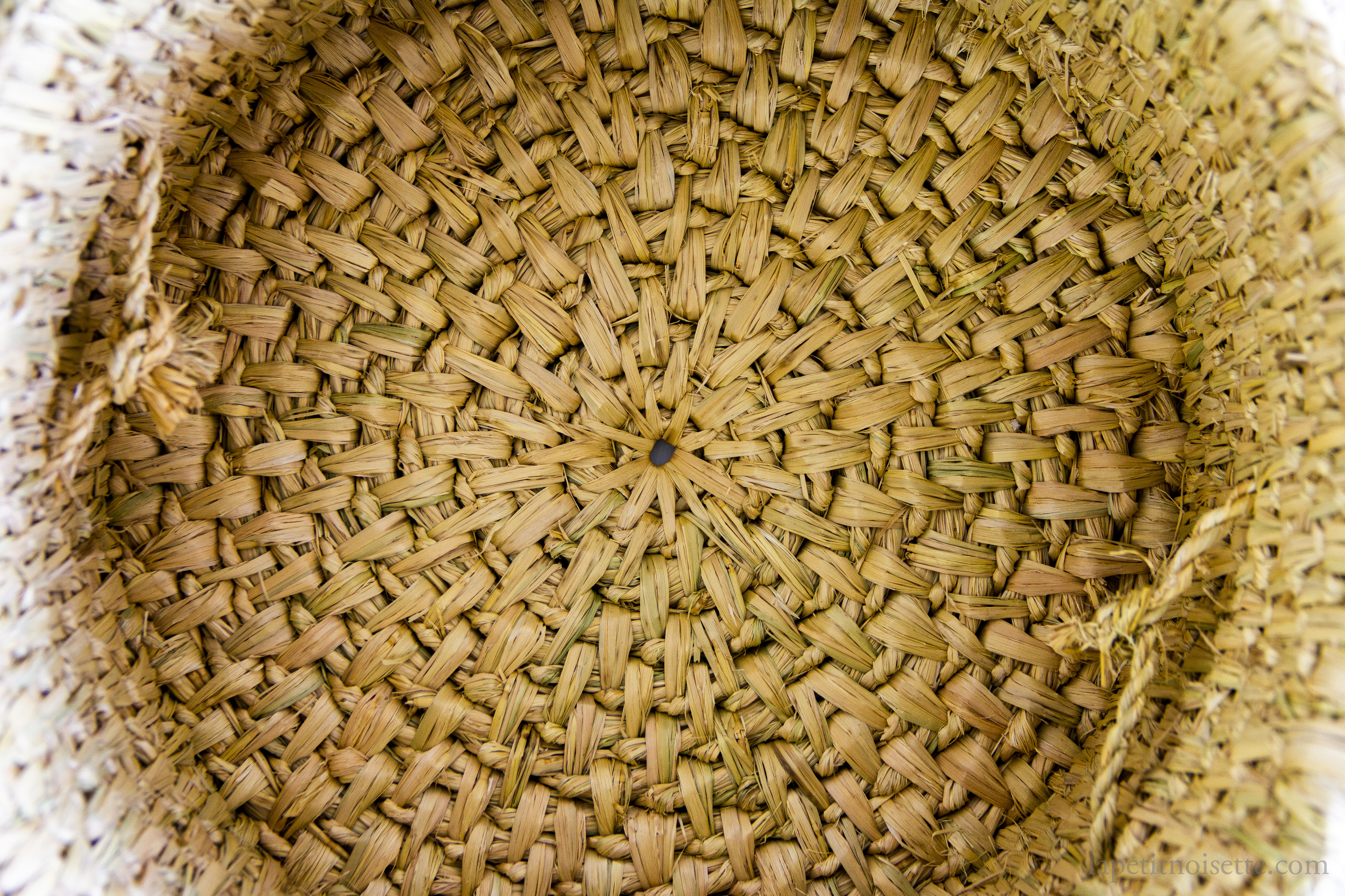 The inside of a traditional japanese straw basket know as a warabitsu used to keep rice warm showing the intricate patterns of weaving.