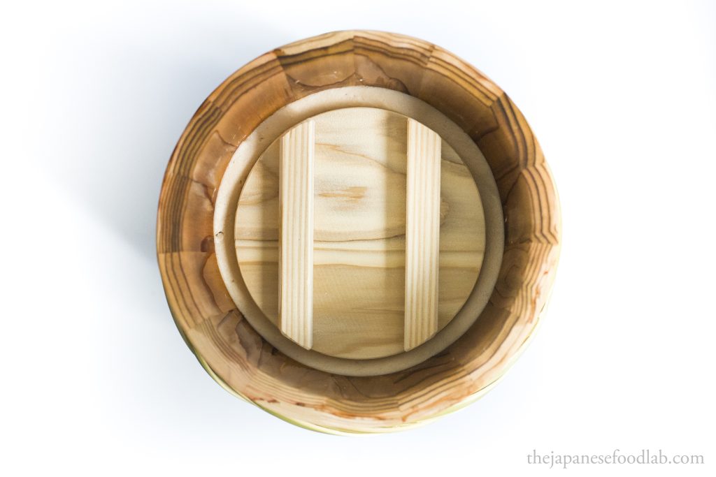 Inside a miso barrel showing a layer of sake lees to prevent oxygen exposure.