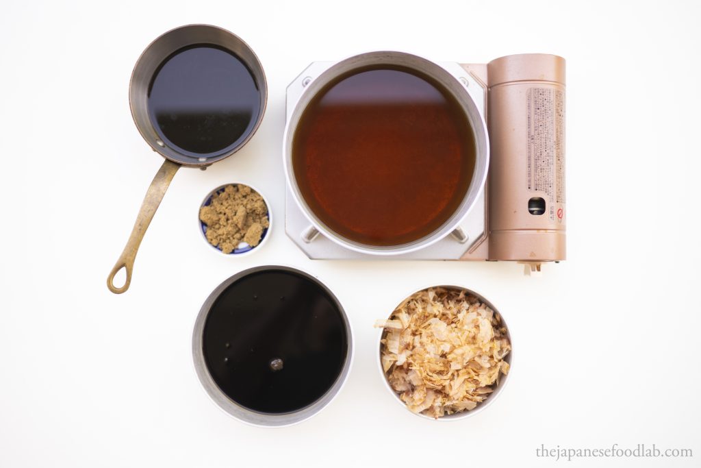 The ingredients used to make tendon tare sauce, which are soy sauce, brown sugar, mirin, sake and katsuobushi, laid out. 